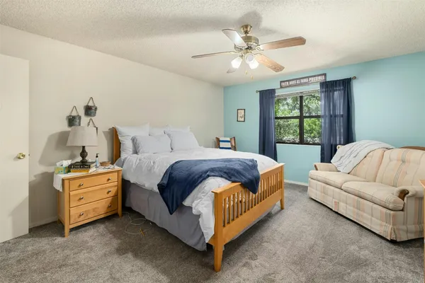 a spacious bedroom with a bed and ceiling fan