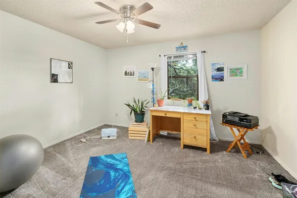 a view of a workspace with furniture and a window
