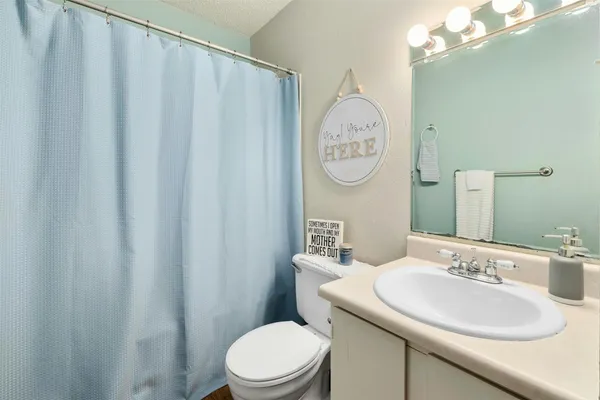 a bathroom with a toilet a sink and a mirror