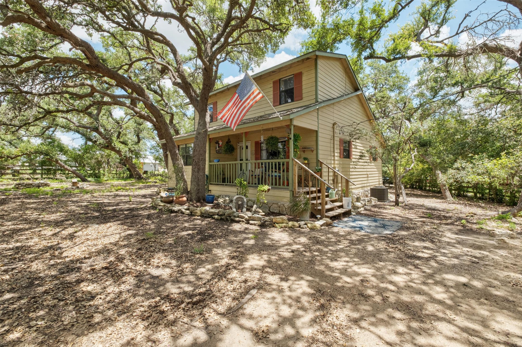 3805 Lone Man Mountain Road Wimberley, TX 78676 - Photo 3 of 19 a view of a white house next to a yard with a tree