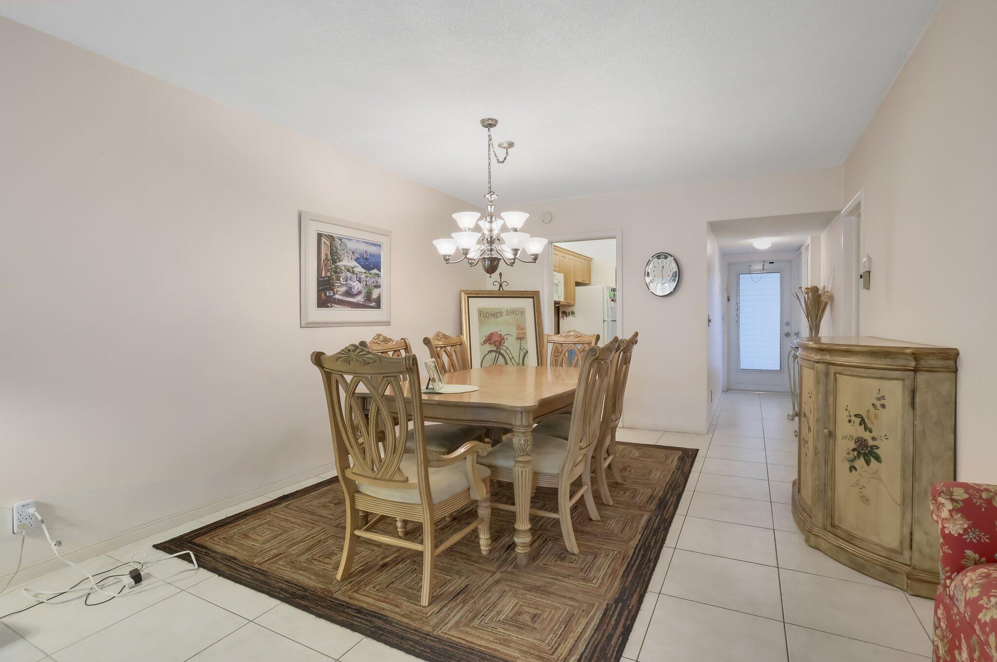 3401 Spanish Trail, Unit 151 Delray Beach, FL 33483 - Photo 12 of 20 a view of a dining room with furniture and chandelier