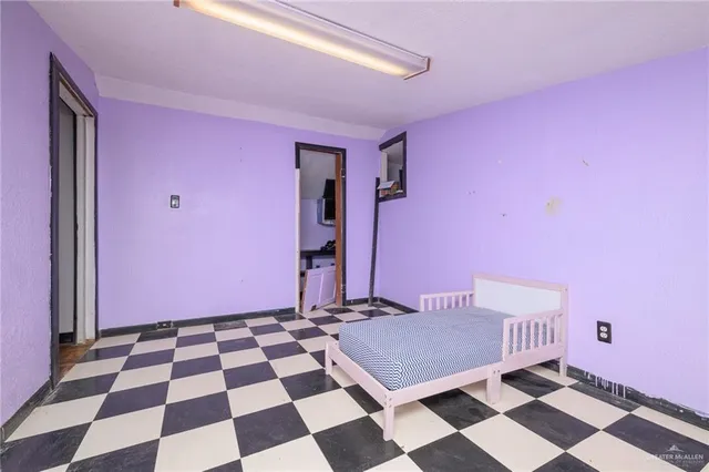 a room with a black white checkered floor with a rug