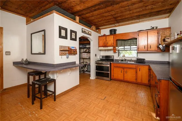 a kitchen with stainless steel appliances granite countertop a stove a sink and a refrigerator