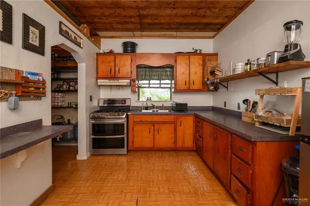 a kitchen with stainless steel appliances granite countertop a stove a sink and a microwave