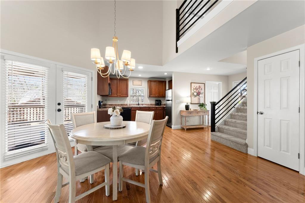 3211 The Trail Road Gainesville, GA 30501 - Photo 7 of 35 a dining room with wooden floor a chandelier a wooden table and chairs