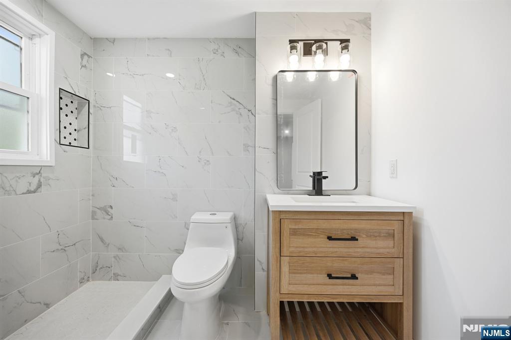 30 West Lawn Road Livingston, NJ 07039 - Photo 18 of 33 a bathroom with a toilet a sink a vanity and mirror