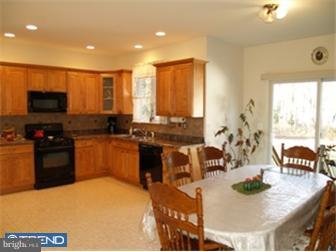 17 Johnson Road Lawrenceville, NJ 08648 - Photo 4 of 12 a kitchen with stainless steel appliances granite countertop a stove a sink a microwave a dining table and chairs