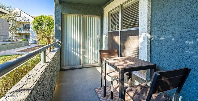 a view of a swimming pool with a table and chairs under an umbrella