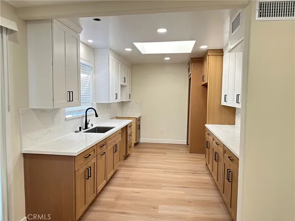 a kitchen with a sink and a wooden floor