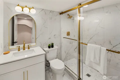 a bathroom with a sink vanity mirror and toilet