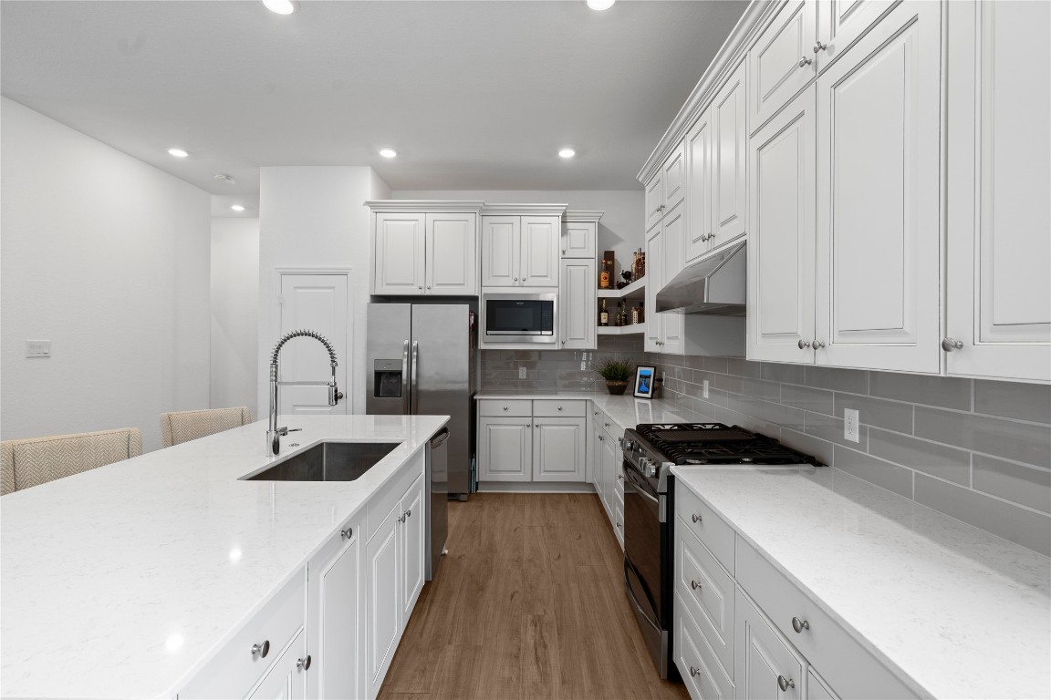 6025 Windward Fls Way Porter, TX 77365 - Photo 14 of 35 a kitchen with stainless steel appliances granite countertop a sink and white cabinets
