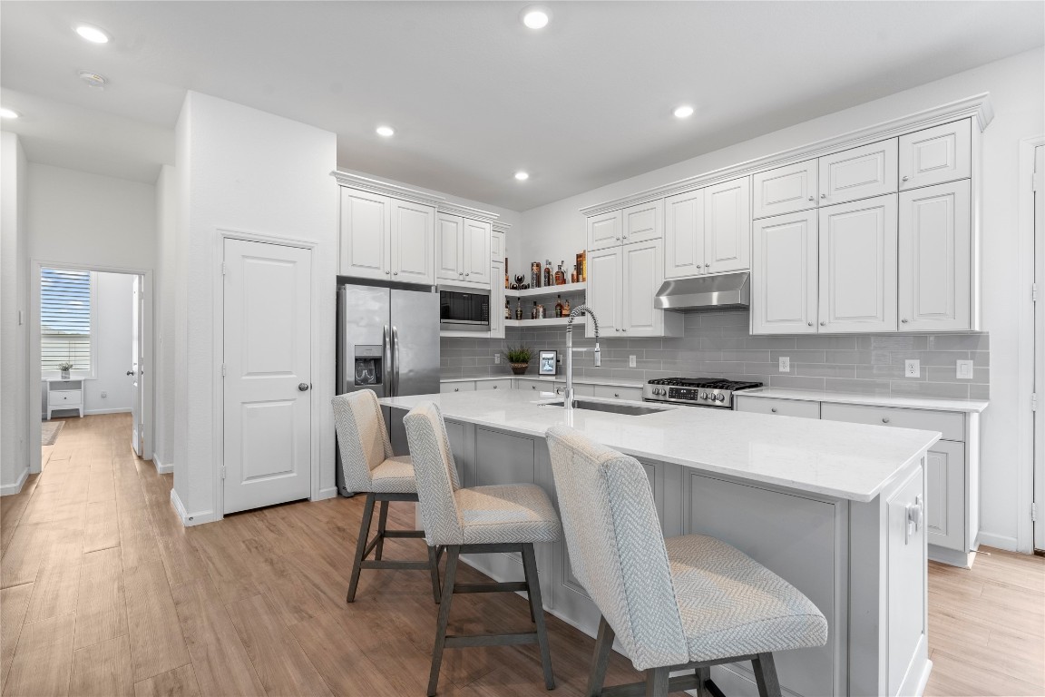 6025 Windward Fls Way Porter, TX 77365 - Photo 15 of 35 a kitchen with kitchen island white cabinets and stainless steel appliances