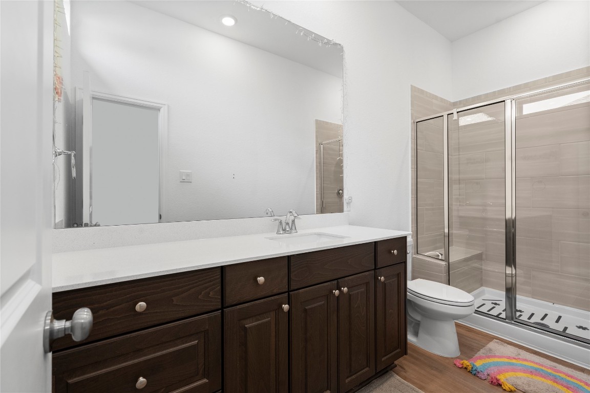 6025 Windward Fls Way Porter, TX 77365 - Photo 19 of 35 a bathroom with a double vanity sink toilet and mirror