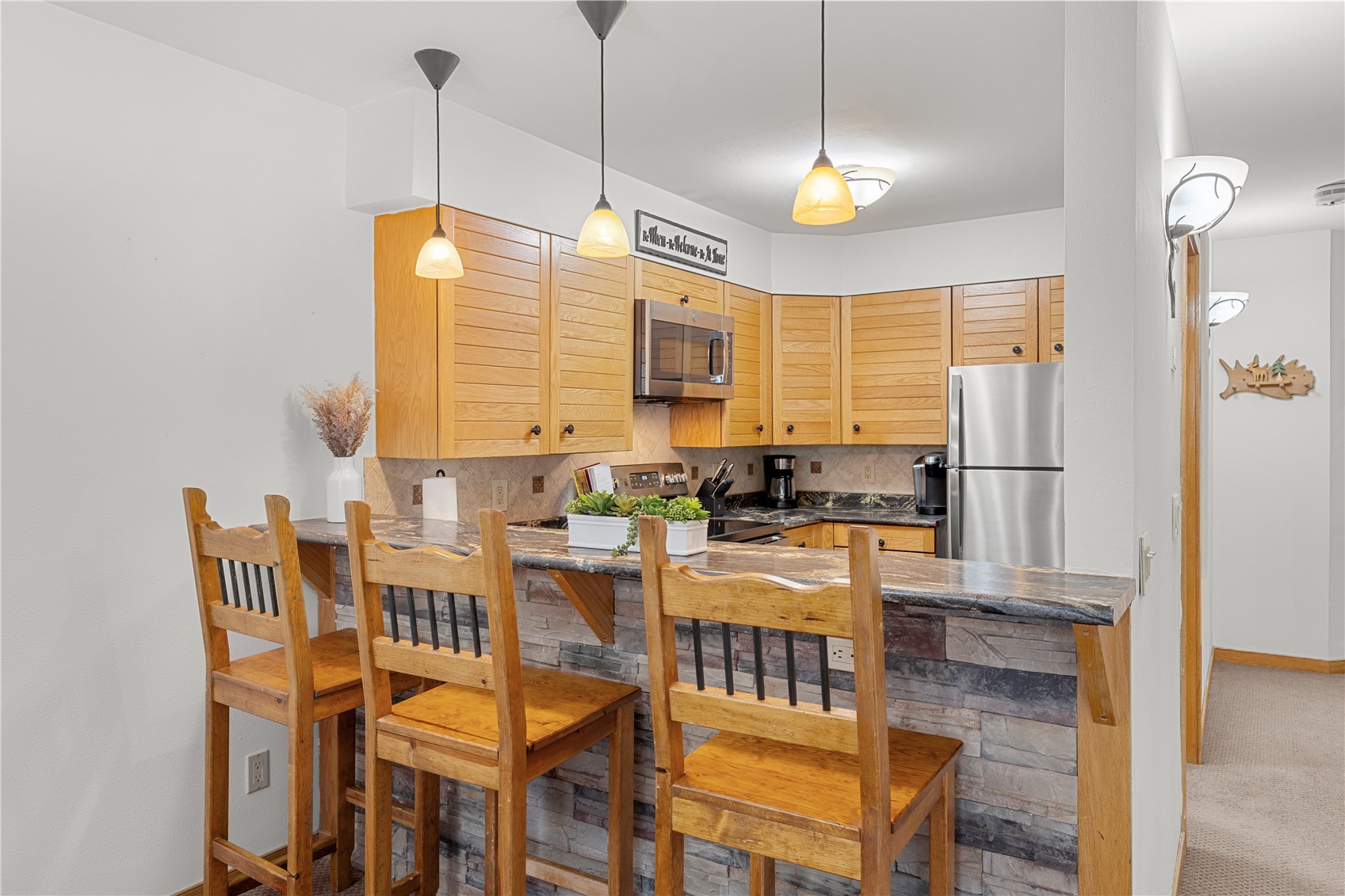 22804 Highway 6, Unit 102 Keystone, CO 80435 - Photo 11 of 34 a kitchen with stainless steel appliances granite countertop a stove a kitchen island a dining table and chairs