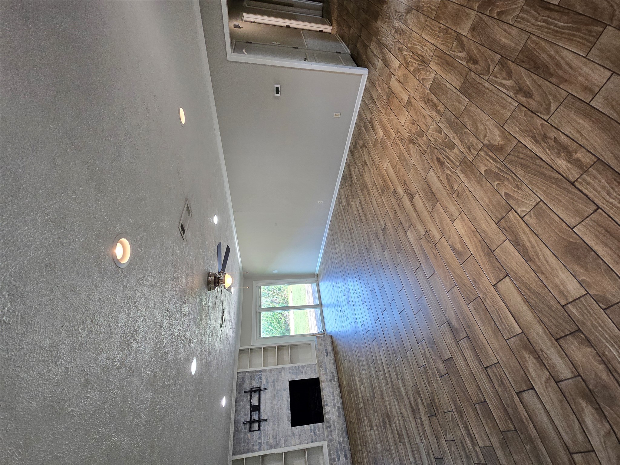 205 East Cherokee Drive Harker Heights, TX 76548 - Photo 4 of 23 A spacious living area features wood-look tile flooring and a cozy fireplace with built-in shelving.