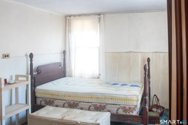 a bedroom with a bed and a window