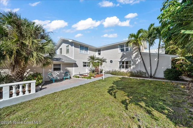 an aerial view of a house with a yard and lake view