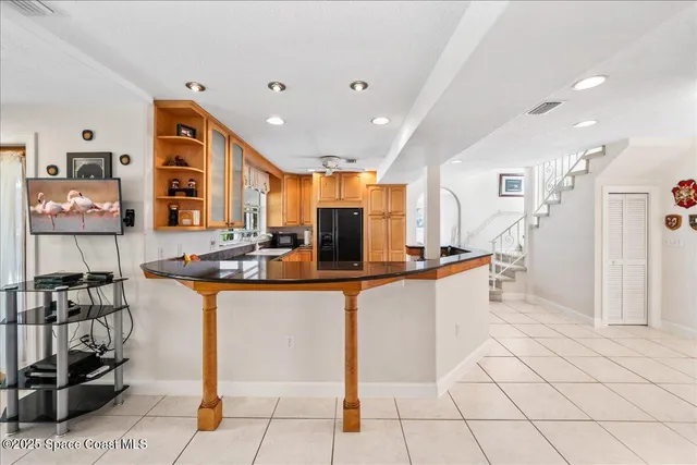 a large white kitchen with stainless steel appliances kitchen island granite countertop a sink and cabinets