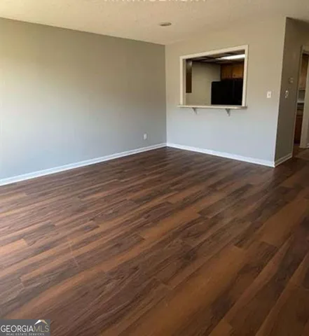 a view of empty room with wooden floor and fireplace