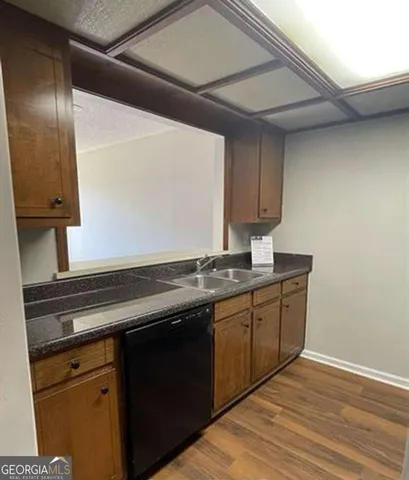 a kitchen with granite countertop a sink and a stove