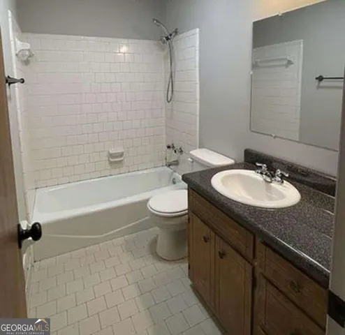 a bathroom with a granite countertop sink toilet mirror and shower