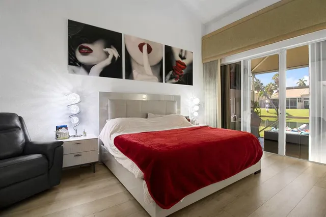 a bedroom with a bed and painting on the wall