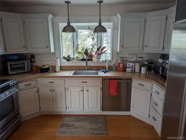 a kitchen with granite countertop a sink stainless steel appliances and cabinets