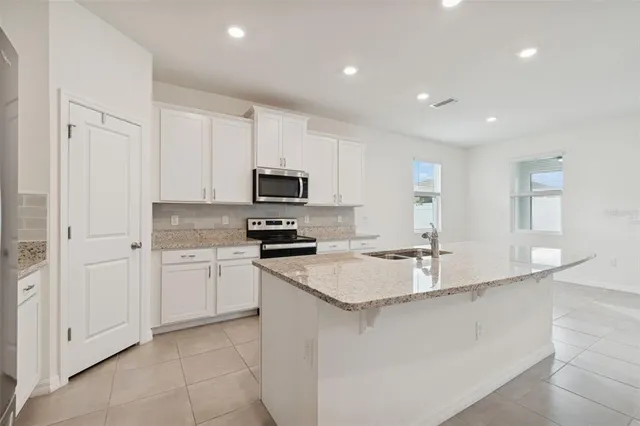 a kitchen with a sink stainless steel appliances and white cabinets