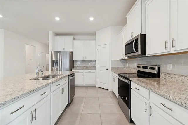a view of kitchen with kitchen island white cabinets and refrigerator