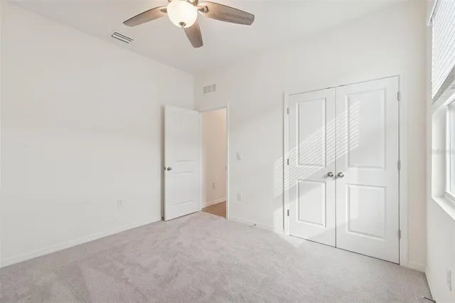 an empty room with a chandelier fan