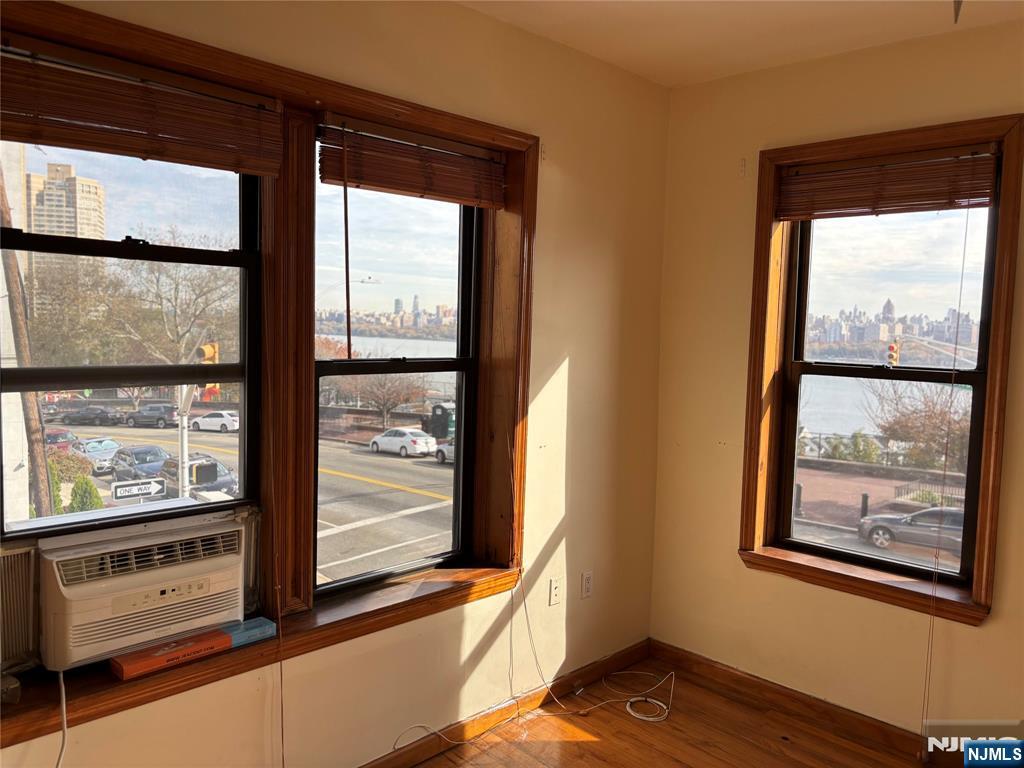 6209 Boulevard, Unit 1EN West New York, NJ 07093 - Photo 2 of 13 a view of an empty room with wooden floor and windows