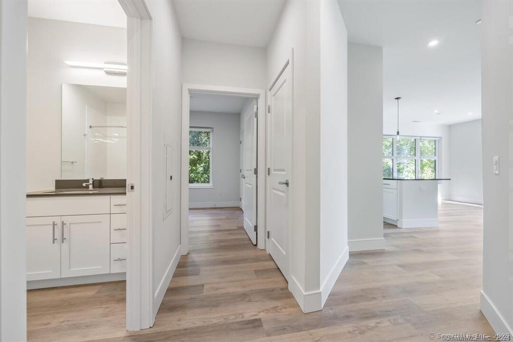 10 A Willard Road, Unit 456 Norwalk, CT 06851 - Photo 21 of 29 a view of a hallway with wooden floor and a living room