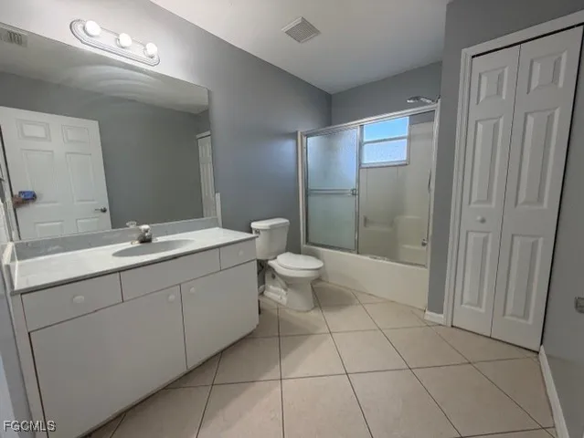 a spacious bathroom with a double vanity sink toilet and a mirror