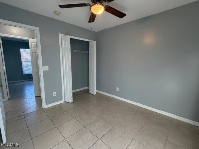 an empty room with wooden floor and chandelier fan