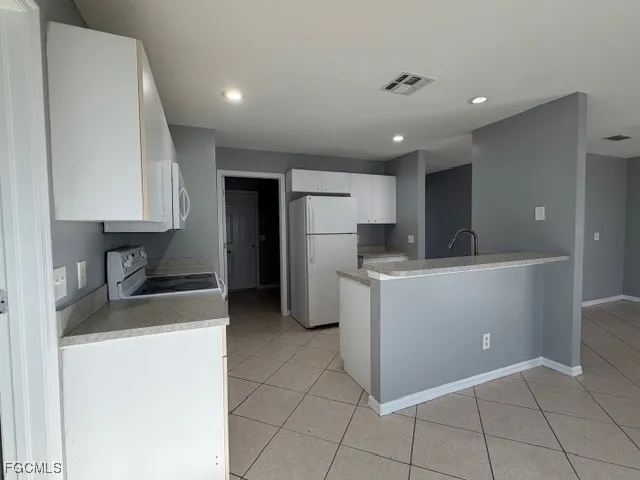 a kitchen with refrigerator and cabinets