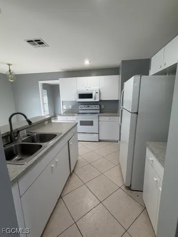 a kitchen with a sink a refrigerator and a stove top oven