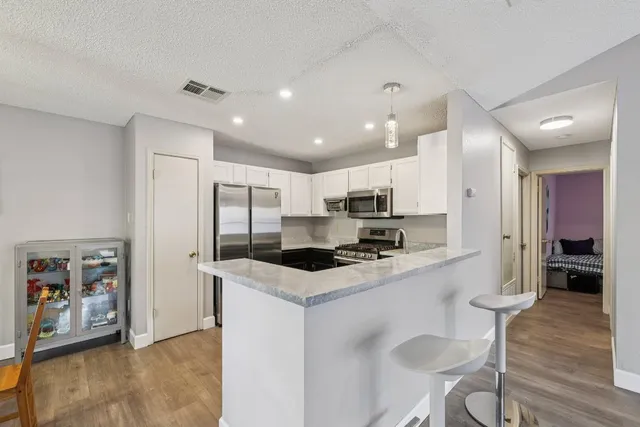 a kitchen with stainless steel appliances kitchen island granite countertop a refrigerator and microwave