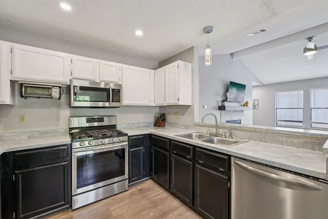 a kitchen with a sink stove and microwave