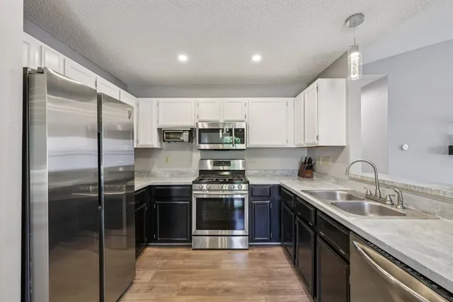 a kitchen with stainless steel appliances granite countertop a sink stove and refrigerator