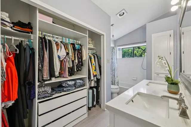a view of walk in closet with clothes and shoes
