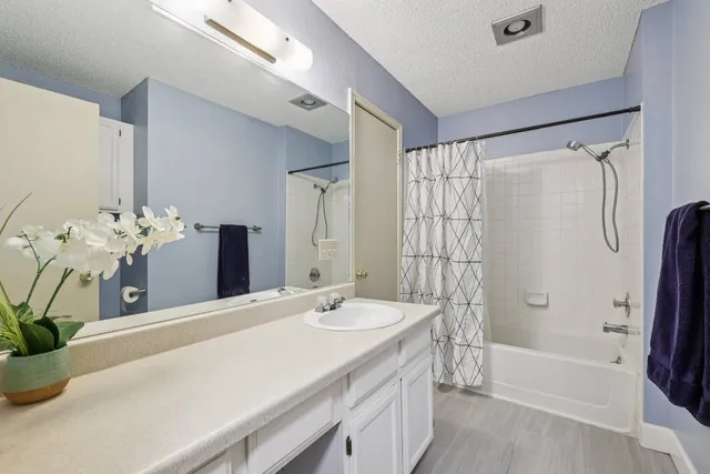 a bathroom with a tub sink and mirror