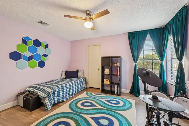 a bedroom with a bed a window and a chandelier