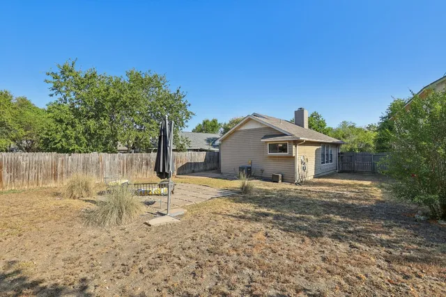 a backyard of a house with table and chairs