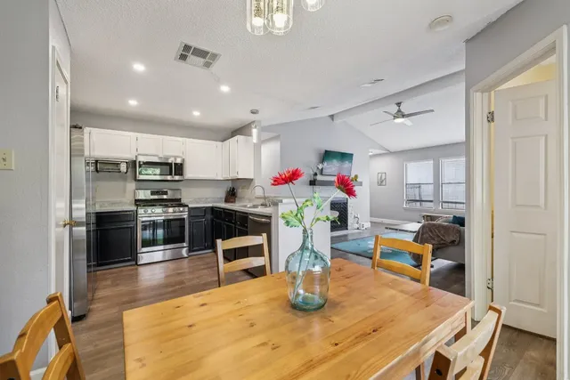 a kitchen with stainless steel appliances granite countertop a sink dining table and chairs