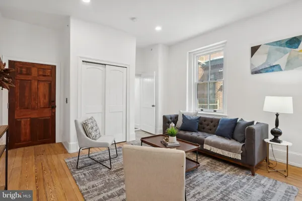 a living room with furniture a wooden floor and a window