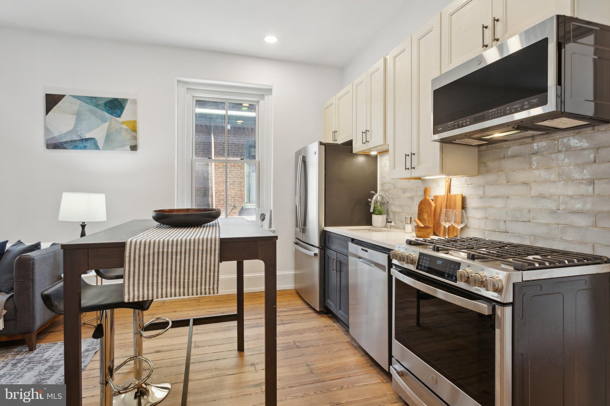 1716 Spruce Street, Unit 8 Philadelphia, PA 19103 - Photo 6 of 13 a kitchen with stainless steel appliances granite countertop a stove refrigerator and a microwave