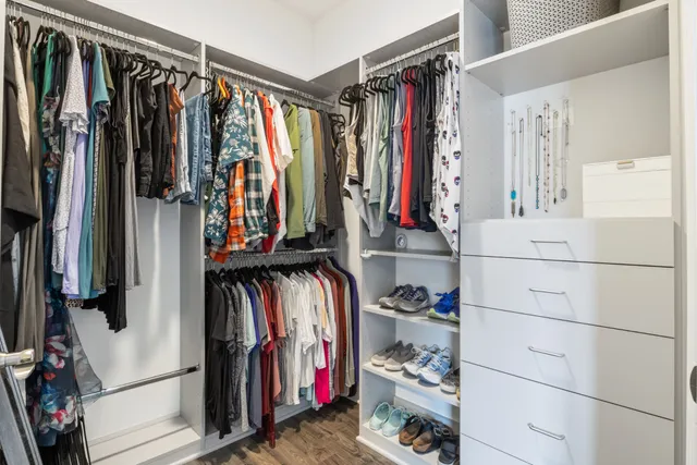 a view of walk in closet with clothes and shoes
