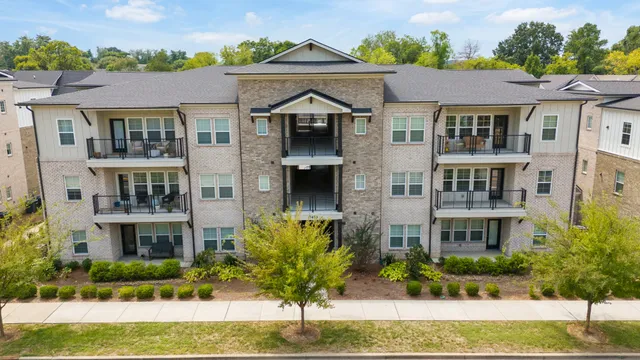 a front view of a houses with yard and green space