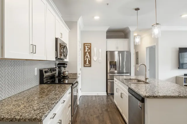 a kitchen with stainless steel appliances granite countertop a sink refrigerator and cabinets