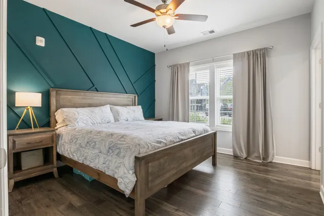 a bed sitting in a spacious bedroom next to a window